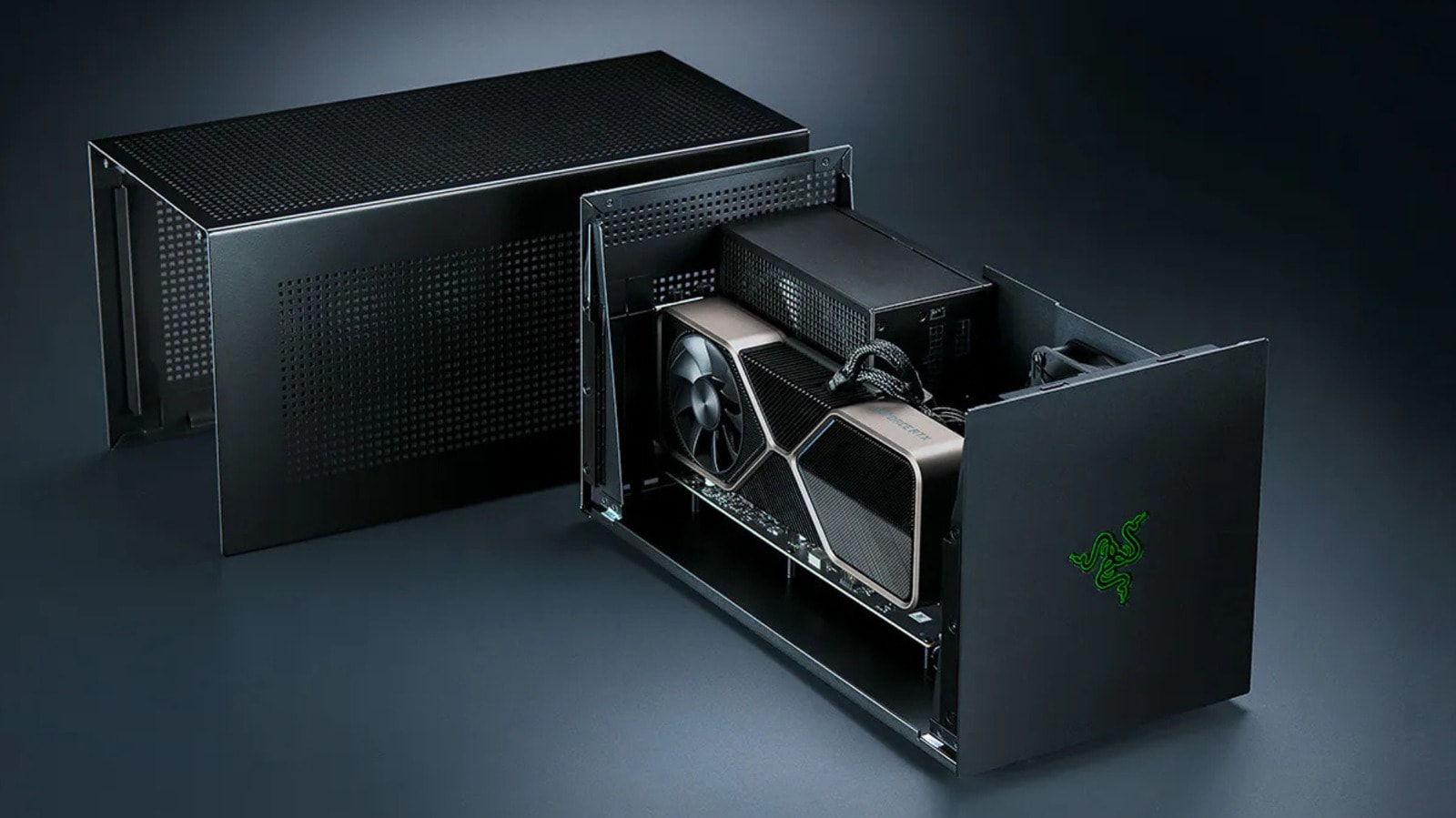 An external GPU enclosure connected to a laptop on a desk.